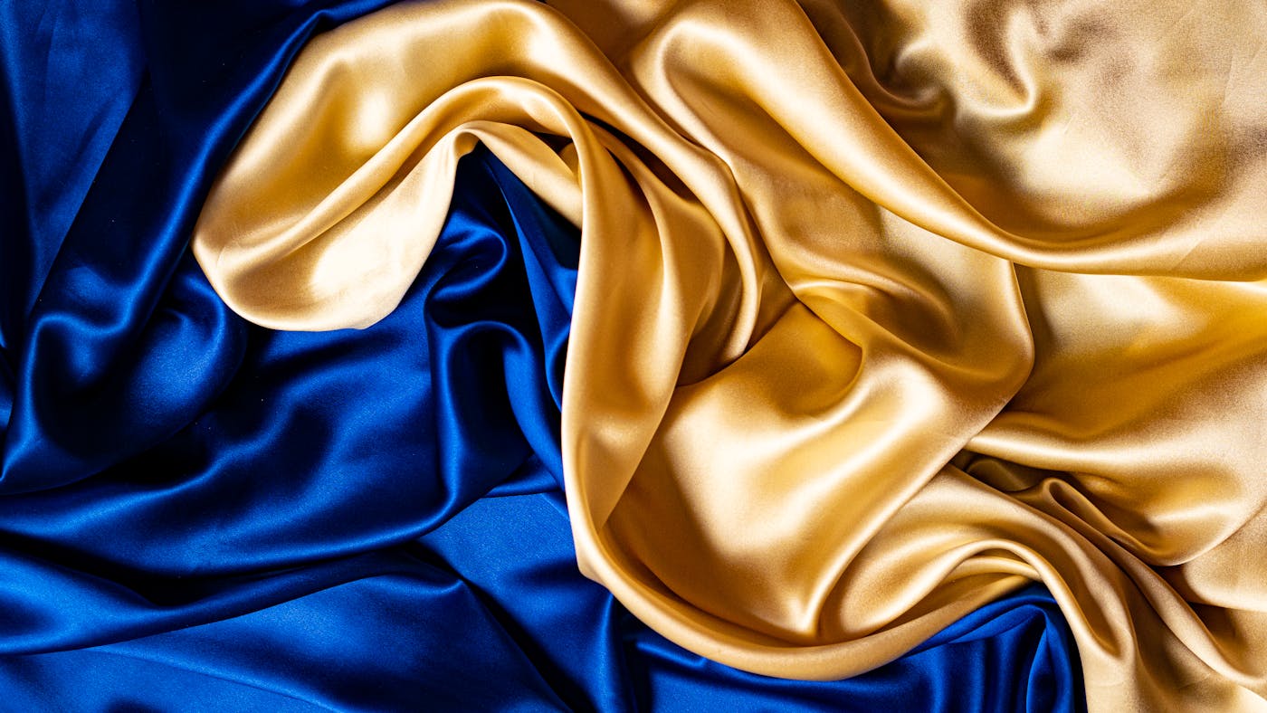 Luxurious blue and gold silk fabric draped elegantly — Kashmir Couture